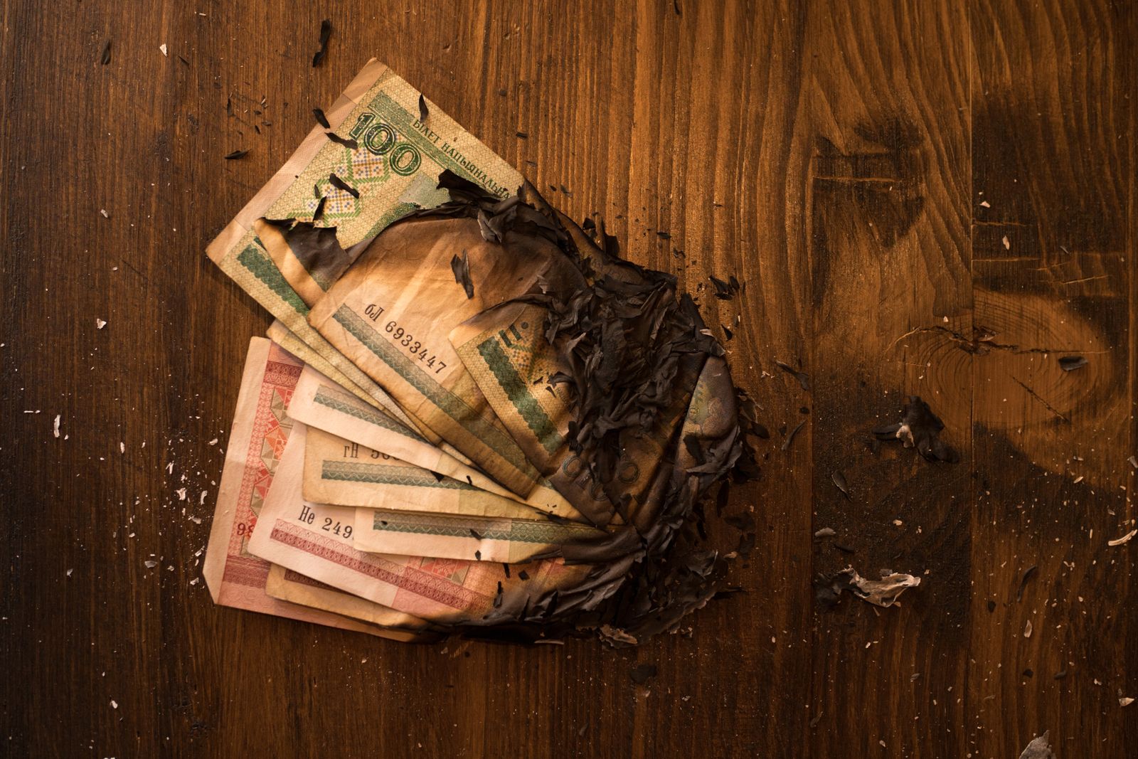 Notas de dinheiro queimadas sobre uma mesa de madeira
